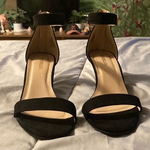 Black high heels with toe show, and one strap